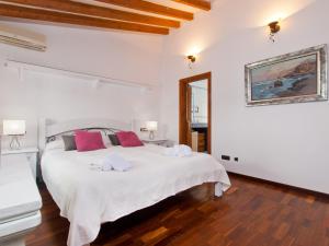 Un dormitorio blanco con una gran cama blanca con almohadas rojas. en House Es Convent in Alcudia, close to beaches, en Alcudia