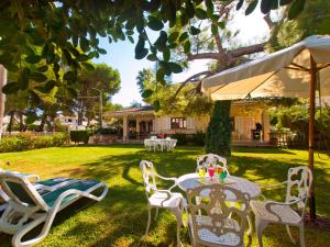 Villa Tita de Manresa, con jardines y vista mar في الكوذيا: طاولة وكراسي في ساحة منزل