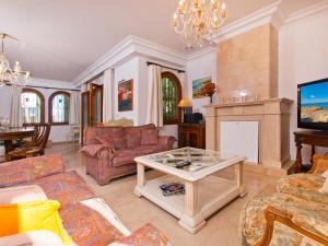 een woonkamer met een bank en een tafel bij Villa Tita de Manresa, con jardines y vista mar in Alcudia