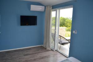 Pokój z przesuwnymi szklanymi drzwiami prowadzącymi na balkon. w obiekcie APARTMENT GLORIA Blue 1 w mieście Malinska