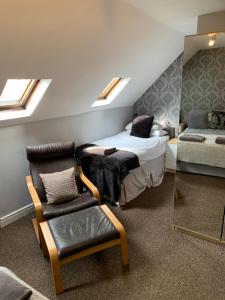 a bedroom with a bed and a chair and a couch at Gillygate Holiday Apartment in York