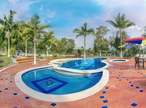 a swimming pool with blue water in a resort at Finca Hotel San Isidro in Hojas Anchas