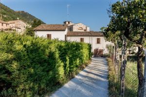 a white house on a hill with a pathway at GuestHost - Borgo Santa Lucia Apartment with Private Parking & Garden in Gubbio