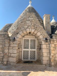 
a brick building with a stone wall and a window at TRULLI TESORO in Cisternino
