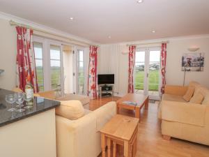 a living room with two couches and a table at 4 Thurlestone Beach House in Kingsbridge