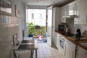 a kitchen with white cabinets and a counter top at Chill Out Apartment, 2 mins from beach in Nice