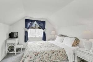 ein weißes Schlafzimmer mit einem Bett und einem Fenster in der Unterkunft 201 Amethyst Avenue in Newport Beach