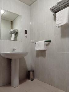Hostal Brin في مونريال ديل كامبو: حمام مع حوض ومرآة