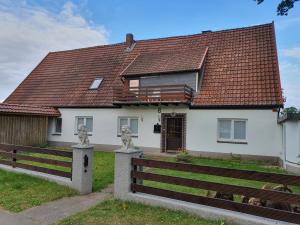 a white house with a brown roof at Zimmer zur Seeve in Seevetal