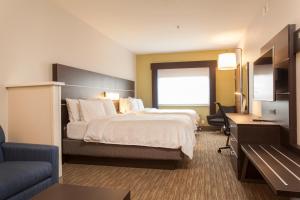  Holiday Inn Express & Suites في سانتا فيه: غرفة الفندق بسرير كبير ومكتب
