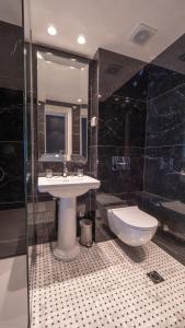 a bathroom with a sink and a toilet at Vivid Blue Serenity Resort in Sveti Stefan