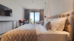 a bedroom with a large bed with a large headboard at Vivid Blue Serenity Resort in Sveti Stefan