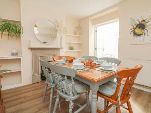 cocina y comedor con mesa de madera y sillas en 3 Lowerbourne Terrace, en Minehead