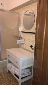 een badkamer met een witte wastafel en een spiegel bij Ferienhaus Anni in Bad Zwischenahn