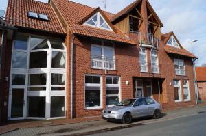 a silver car parked in front of a brick building at Hotel zur Post in Steimbke
