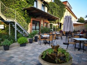 a patio with tables and chairs and a fountain at Hotel Steyerberger Hof in Steyerberg