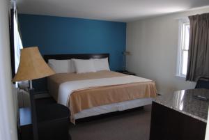 Habitación de hotel con cama y pared azul en Shore Point Motel, en Point Pleasant Beach