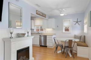 a white kitchen with a table and a fireplace at 307 Thirty Fifth Street in Newport Beach