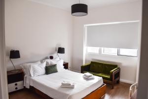 リベイラ・グランデにあるA Casa do Outeiroのベッドルーム1室(ベッド1台、緑の椅子付)