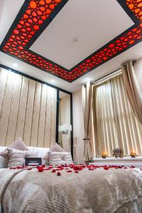 a bedroom with a large bed with red flowers on it at Aphrodite Suites in Bradford