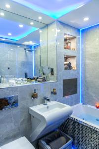 a bathroom with a white sink and a tub at Aphrodite Suites in Bradford