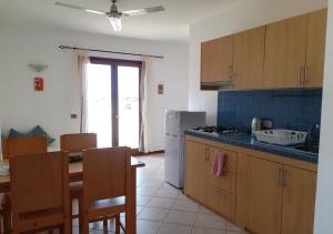 a kitchen with a table and a refrigerator and a table and chairs at Pedra do Sol Praia Estoril Sal Rei FREE WI-FI in Sal Rei +34 photos