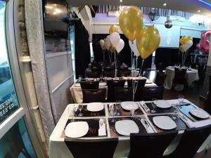 a group of tables with yellow balloons in a room at Star Guest- House in Or Yehuda
