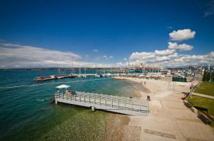 a pier on a beach with people on the water at APARTMA IVA in Koper