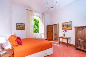 ein Schlafzimmer mit einem großen orangenen Bett und einem Fenster in der Unterkunft Bastide Saint-Estève in Brue-Auriac