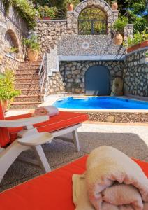 un modèle de piscine avec une table et un banc dans l'établissement Villa Teste di Moro, à Capri