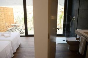 ein Badezimmer mit einem Bett, einem Waschbecken und einer Toilette in der Unterkunft Duna Colorada 4 in Lajares