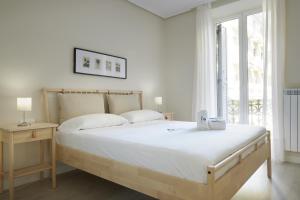 um quarto branco com uma cama grande e uma janela em Xingola - Basque Stay em San Sebastián