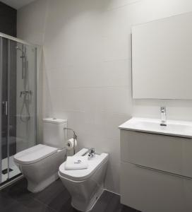 uma casa de banho branca com um WC e um lavatório em Xingola - Basque Stay em San Sebastián