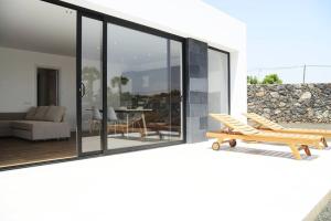 ein Haus mit Glasschiebetüren und einer Terrasse in der Unterkunft Duna Colorada 4 in Lajares