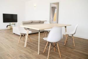 ein Esszimmer mit einem Tisch und weißen Stühlen in der Unterkunft Duna Colorada 4 in Lajares