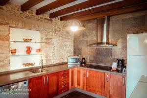 a kitchen with wooden cabinets and a white refrigerator at Casas Do Consul - Mar y Montaña in O Vicedo +18 photos