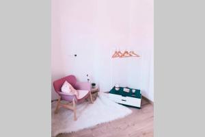 een woonkamer met een roze stoel en een spiegel bij Pink studio Mons ✓ TOP position ! in Bergen