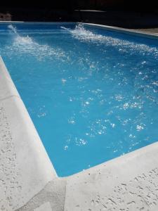 una piscina con agua azul. en Complejo Quimpe en Villa Giardino