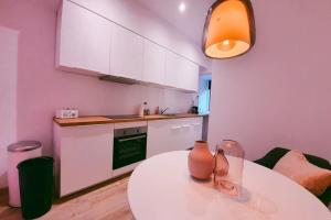a kitchen with a table with two vases on it at Pink studio Mons ✓ TOP position ! in Mons