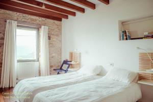 a bedroom with two beds and a chair and a window at Casas Do Consul - Mar y Montaña in O Vicedo