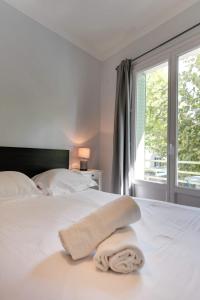 een slaapkamer met een wit bed met een raam bij Le Baulier - 2 bedrooms apartment in Annecy +6 foto's