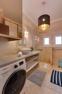 a bathroom with a washing machine and a sink at Le Baulier - 2 bedrooms apartment in Annecy