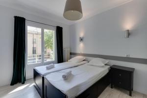 twee eenpersoonsbedden in een kamer met een raam bij Le Baulier - 2 bedrooms apartment in Annecy
