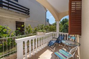 einen Balkon mit zwei Stühlen und einem Zaun in der Unterkunft Apartmani Merica in Pakoštane