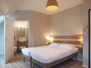 a bedroom with a large bed and a bathroom at Le Roc'h Ar Mor in Ouessant