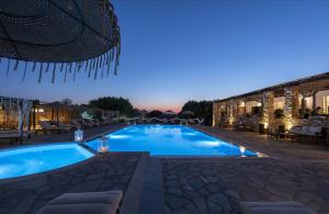 a swimming pool in a resort at night at Parosland Hotel in Aliki