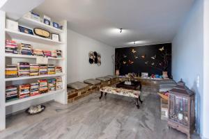a room with a table and a bench and books at Parosland Hotel in Aliki