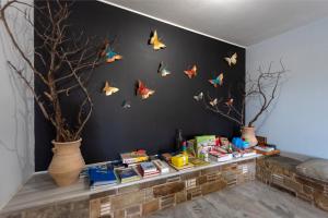 a room with a shelf with books and butterflies on the wall at Parosland Hotel in Aliki