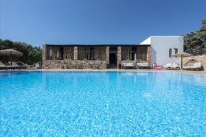 a large blue swimming pool in front of a building at Parosland Hotel in Aliki