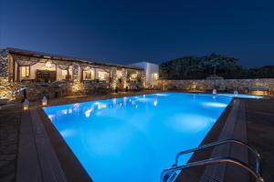 a large swimming pool at night with a building in the background at Parosland Hotel in Aliki